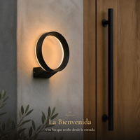 ANELLO I aro negro encendido en muro de microcemento junto a puerta de madera con jaladera negra