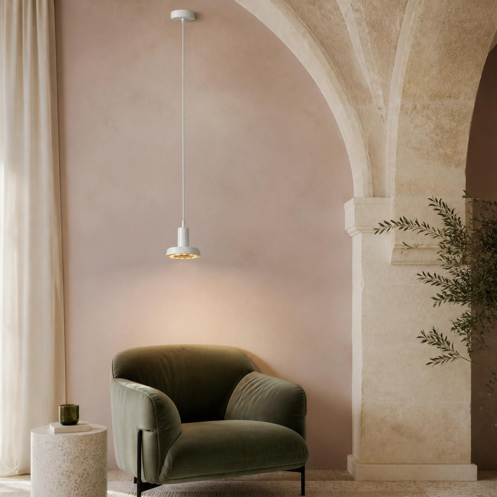 BELEL I blanca sobre sillón verde en sala abovedada