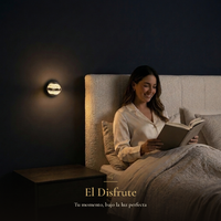 El Disfrute: mujer leyendo en la cama bajo la luz cálida del arbotante BURBIA WALL