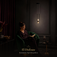 Mujer leyendo en sillón verde bajo CANDEA I encendida