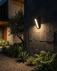 CEFEO II encendida en muro de piedra de patio con jardín de noche