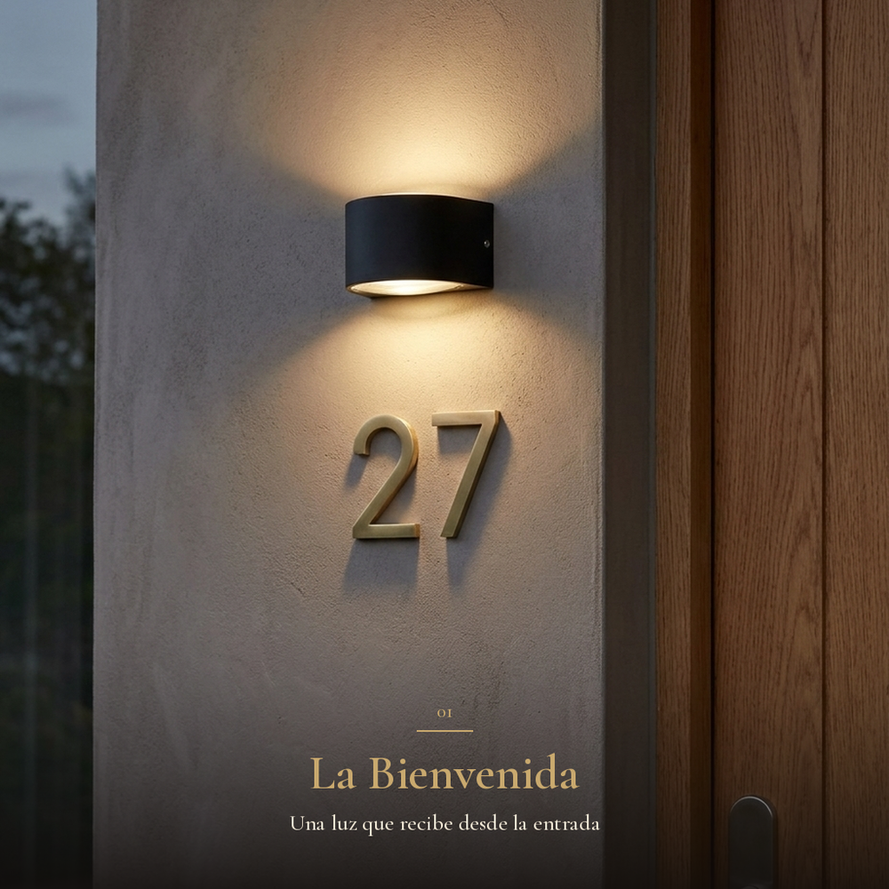 La Bienvenida: arbotante CINCEL iluminando la fachada de entrada sobre el número de casa junto a la puerta