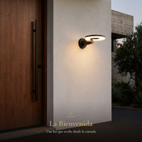 La Bienvenida: arbotante DISCOR WALL iluminando la entrada junto a puerta de nogal con jaladera negra