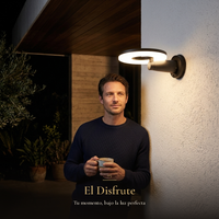El Disfrute: hombre con taza de café bajo la luz cálida del arbotante DISCOR WALL en terraza de noche
