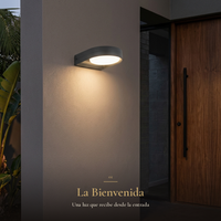 La Bienvenida: arbotante GIDI encendido junto a la puerta de nogal en la entrada de una residencia moderna