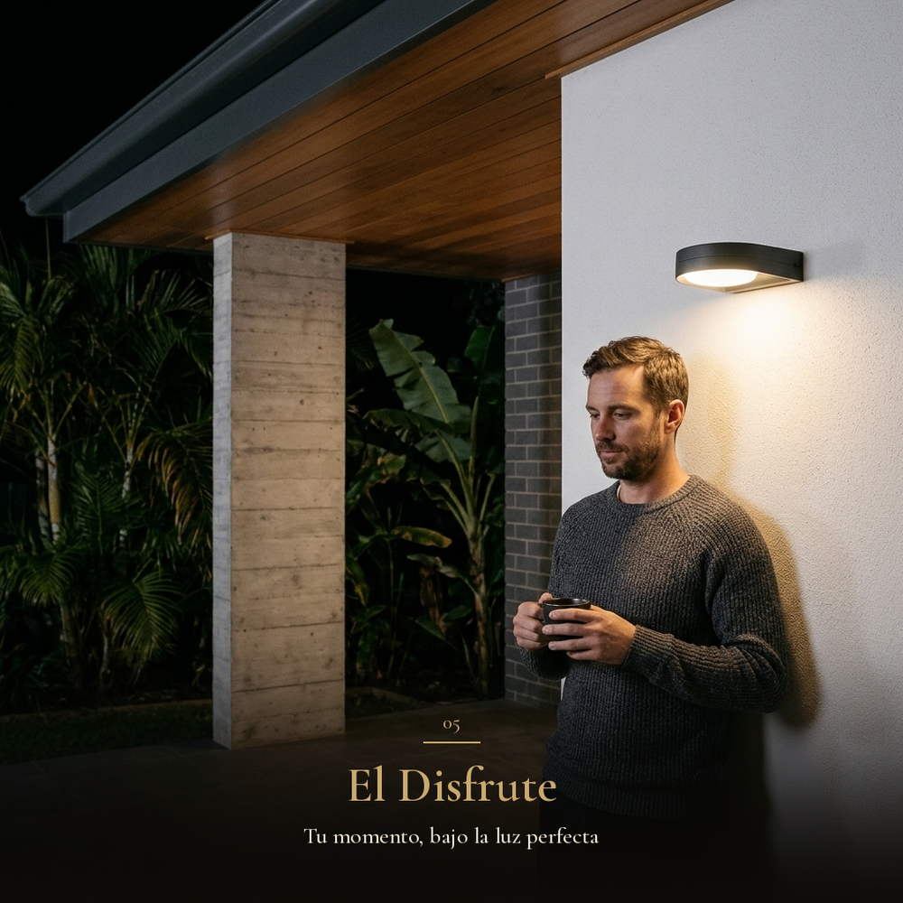 El Disfrute: hombre con café en la terraza bajo la luz cálida del arbotante GIDI por la noche