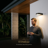 El Disfrute: hombre con café en la terraza bajo la luz cálida del arbotante GIDI por la noche