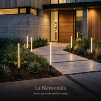 estacas GRAS II encendidas a lo largo del camino de entrada de una casa al atardecer