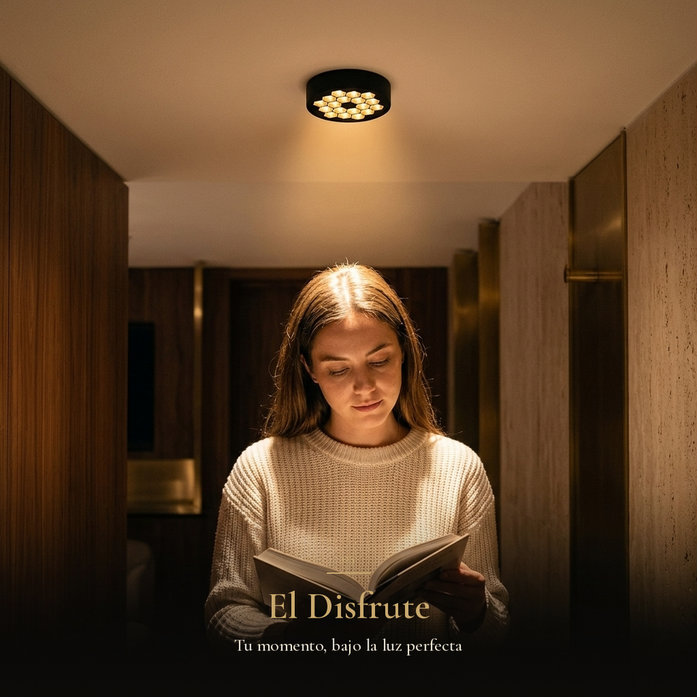 El Disfrute: mujer leyendo un libro bajo la luz cálida del plafón HIVE PTL II en un pasillo de noche