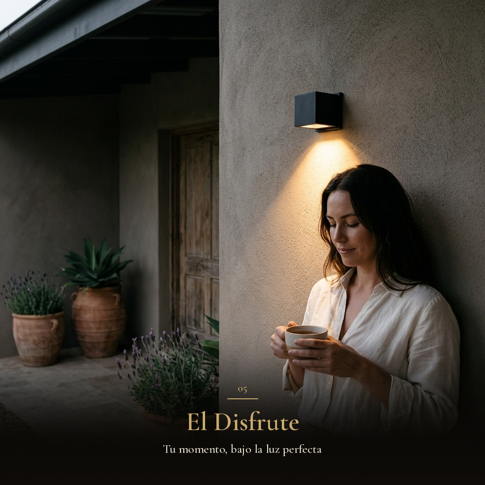 El Disfrute: mujer con taza de té bajo la luz cálida del arbotante KEENYA I en terraza al anochecer