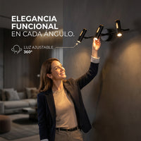 Mujer orientando un spot de ZUBENE IV negro de 3 luces en muro de sala