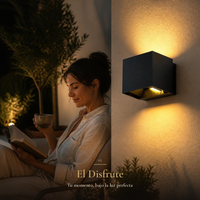 Mujer leyendo con una taza de té en patio de noche junto a PIRQA encendido en muro de estuco