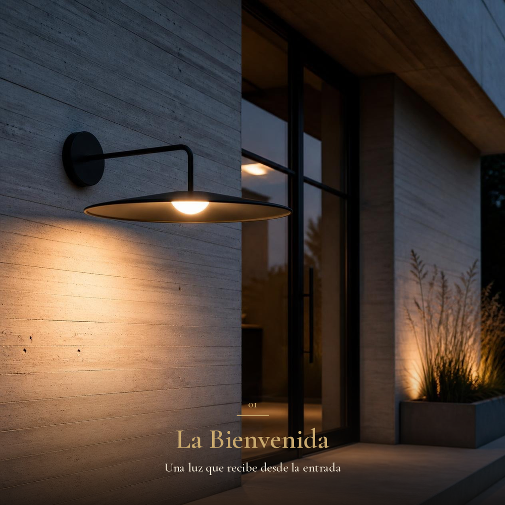 TITA I arbotante negro de disco encendido junto a puerta de vidrio en muro de concreto al anochecer