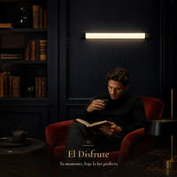 Hombre leyendo en sillón rojo bajo ZYRA encendida
